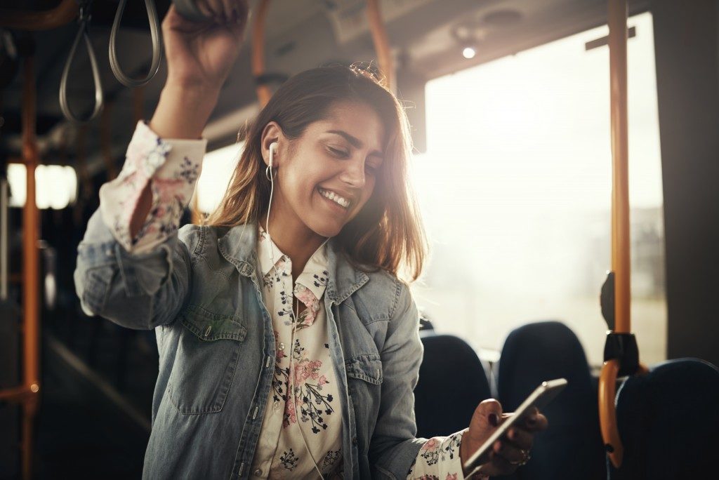 Woman listening to music in her phone while inside the bus