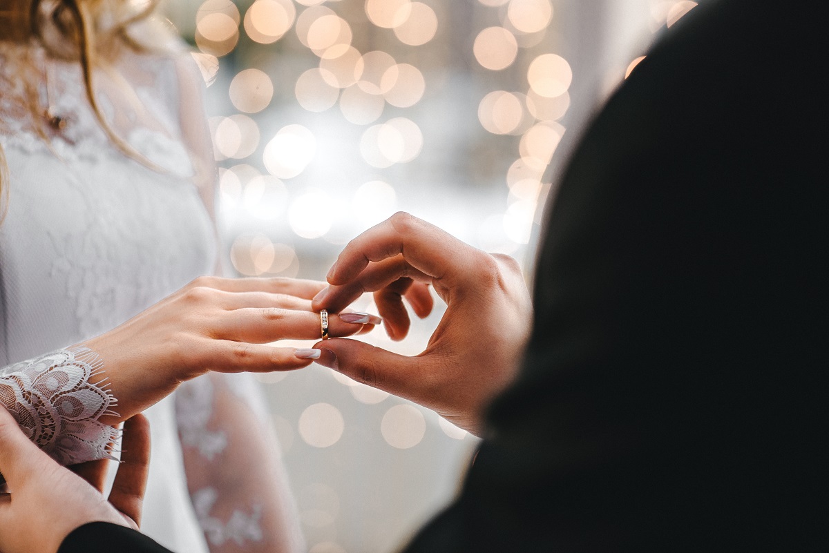 man putting a ring on girl's finger