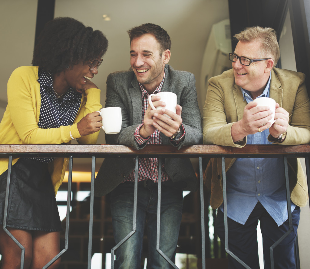 group of people smiling while having coffee