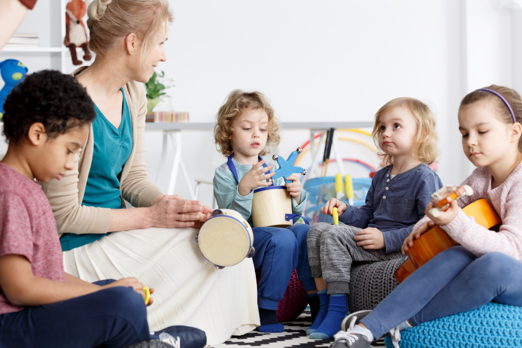 A group of kids trying to play musical instruments in a class