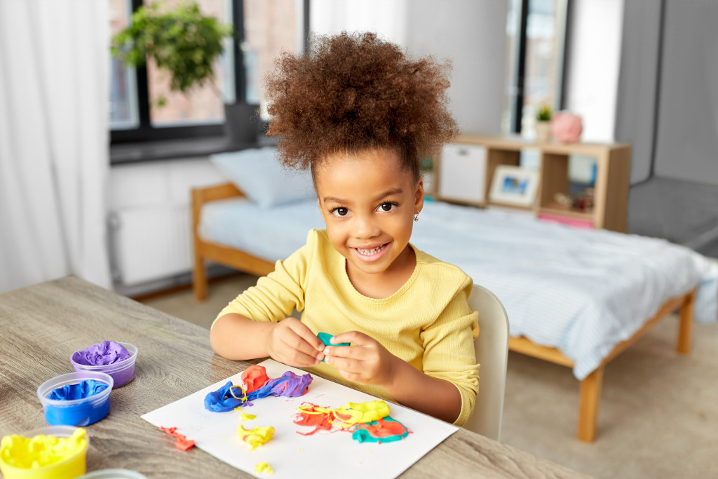 A child playing with colorful clay at home