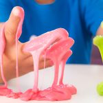 boy's hands covered in pink and green slime