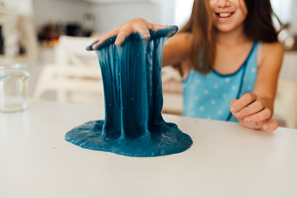 girl pulling blue slime up with her hand