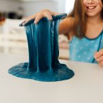 girl pulling blue slime up with her hand