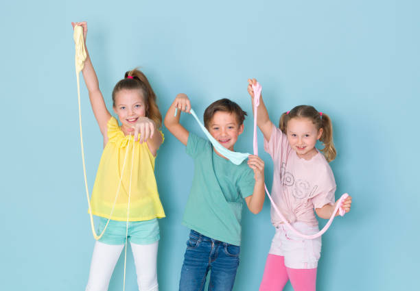 three kids playing with fluffy slime